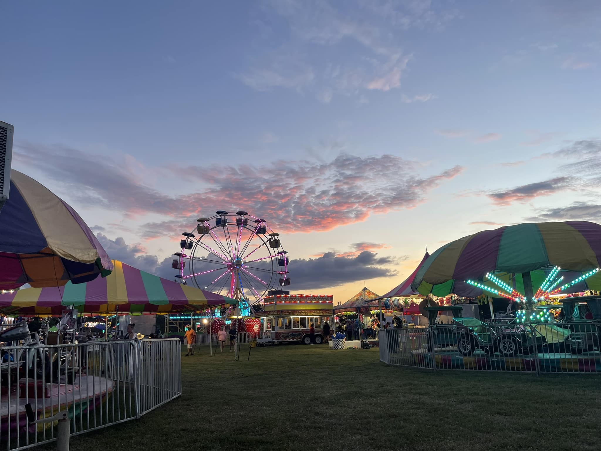 Ferris wheel and carnival rides at the Tippah County Fair at sunset